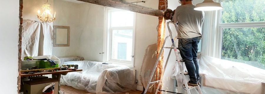 mężczyzna remontuje dom
